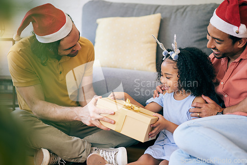 Image of Gay, Christmas and a father with a gift for a child, celebration and holiday as a family. Smile, home and an lgbt man with a festive present for a girl kid in the living room of a house together