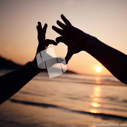 Image of Beach sunset, nature silhouette and person with heart hands sign for love, freedom and ocean vacation. Adventure, emoji health icon and couple support with natural wellness, tropical care or shape