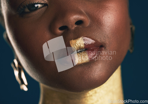 Image of Portrait, beauty and black woman in gold for culture, heritage or tradition on a blue background in studio. Face, skincare and african style with a young model closeup for elegance or cosmetics