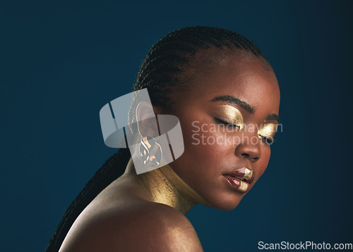 Image of Gold makeup, studio face and black woman relax with creative art, facial cosmetics paint and beauty. African culture, color and person with eyes closed, wellness and creativity on blue background