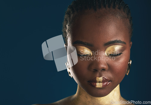 Image of Gold makeup, face and black woman relax with creative art mockup, facial cosmetics paint or beauty advertising space. African culture, color and studio person glow with eyes closed on blue background