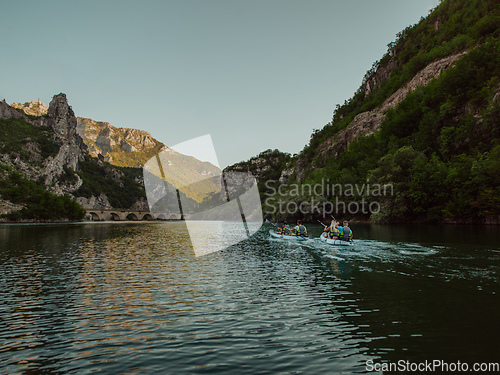 Image of A group of friends enjoying having fun and kayaking while exploring the calm river, surrounding forest and large natural river canyons