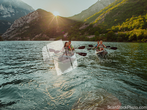 Image of A group of friends enjoying fun and kayaking exploring the calm river, surrounding forest and large natural river canyons during an idyllic sunset.