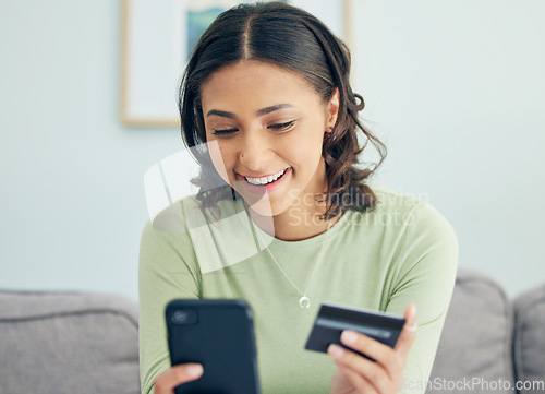 Image of Credit card, phone and woman on a sofa happy for cashback, savings or ecommerce sale in her home. Smartphone, and female customer in a living room smile for sign up, survey or bank, payment or budget