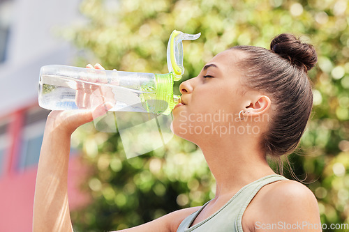 Image of Woman, fitness and drinking water in nature for sustainability after workout, training or outdoor exercise. Thirsty female person with bottle for natural nutrition, mineral or liquid diet in the park