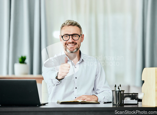Image of Portrait, thumbs up and smile with a business man in his office for support, motivation or success. Thank you, yes emoji and goals with a happy professional manager working in a notebook at his desk
