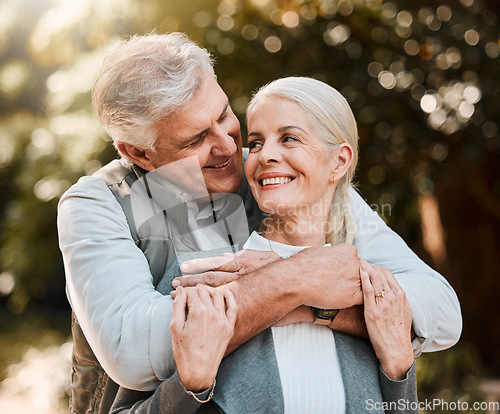 Image of Love, hug and senior couple at a park happy, free and enjoy travel, holiday or weekend outdoor. Face, smile and elderly man embrace woman in forest, bond and having fun on retirement trip together