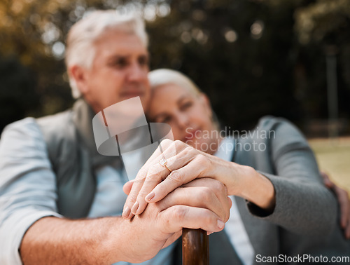 Image of Holding hands, couple and a cane in nature for love, bonding and support. Peace, closeup and a senior man and woman in a park with a walking stick, care and together in a garden with a hug on a date
