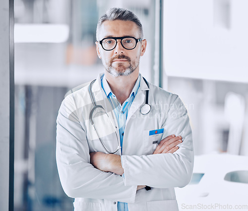 Image of Mature doctor man, arms crossed and portrait for leadership in hospital, medical research or serious face for wellness. Professional medic, healthcare expert and clinic management job in Los Angeles