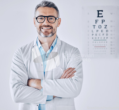 Image of Portrait, eye exam and arms crossed with an optometrist man in his office for healthcare or vision improvement. Medical, frame and glasses with a happy doctor in a clinic for assessment and testing