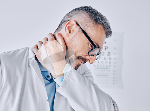 Image of Healthcare, neck pain or optometry and a doctor in his office with an injury while feeling stress. Medical, burnout or accident with a mature optician holding his spine or shoulder in a clinic