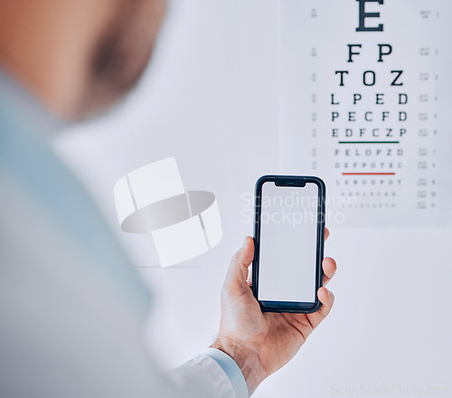 Image of Phone, screen and hand of person in eye exam, test or booking assessment for vision with mobile app or internet. Cellphone, mockup and optometrist doctor testing eyesight in office with technology