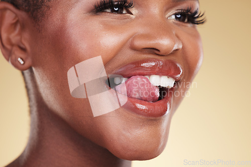 Image of Tongue out, makeup and black woman smile in studio for cosmetic wellness on brown background. Beauty, face and African female model with emoji flirt expression or glowing skin, result or satisfaction