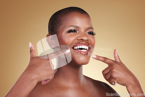 Image of Teeth, beauty and a woman pointing at smile in studio for skin care, glow or cosmetics. Face of African model person with dental shine, dermatology and makeup announcement on a beige background