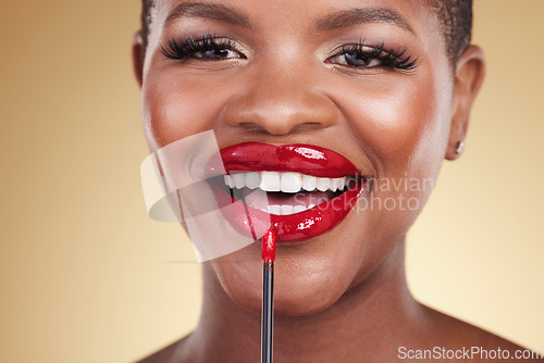 Image of Makeup brush, beauty and a woman with red lipstick in studio for closeup, glow or cosmetics. Face of happy African person with facial shine, dermatology and application on mouth on a beige background