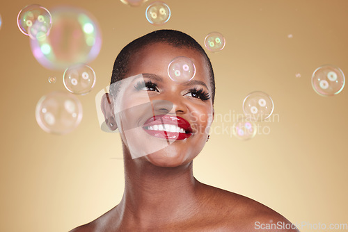 Image of Smile, makeup and bubbles with face of black woman in studio for cosmetics, spa treatment and luxury. Skincare, dermatology and self care with model on gold background for glow, facial and beauty