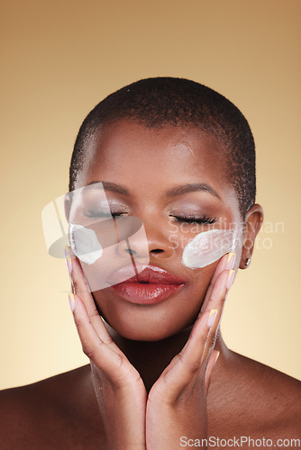 Image of Face, cream and beauty of black woman in studio for self care, skincare or cosmetics. Headshot of african person or aesthetic model with facial moisturizer, dermatology and glow on a beige background