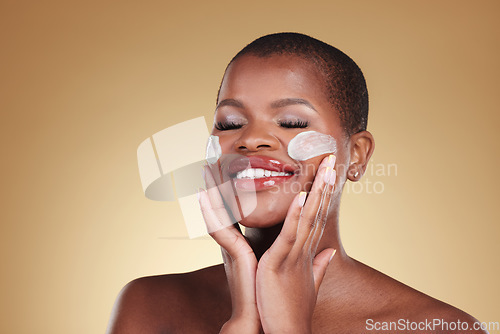 Image of Happy, skincare and black woman with face cream in studio for makeup removal and wellness on brown background. Facial, cleaning and model with moisturizer, exfoliate or beauty, dermatology or mask