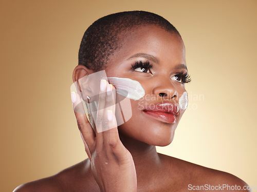 Image of Application, skincare and face cream for black woman in studio for dermatology or cosmetic wellness on brown background. Beauty, hand and model with facial, sunscreen or collagen, mask or scrub