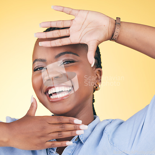 Image of Hands, face frame and portrait of black woman in studio for confidence, creativity and beauty. Photography, perspective and happy African person on yellow background in cosmetics, makeup and glamour