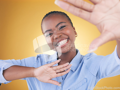 Image of Hands, frame and portrait of black woman in studio smile for confidence, creativity or beauty. Photography, perspective and face of African person on yellow background in cosmetics, makeup or glamour