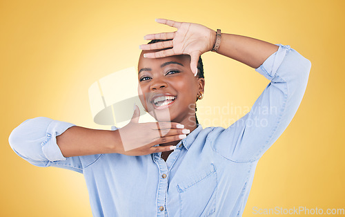 Image of Hands, frame and portrait of happy black woman in studio for confident, creativity and beauty. Photography, perspective and face of African person on yellow background in cosmetics, makeup or glamour
