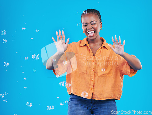 Image of Excited, laugh and black woman on blue background with bubbles for happiness, joy and have fun. Playful, happy smile and isolated African person in studio with soap bubble for freedom and color