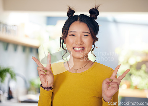 Image of Peace, hands and portrait of Asian woman in home with happiness, v sign or gen z person in kitchen, living room or apartment. Happy, girl and unique fashion in house with confidence and smile on face