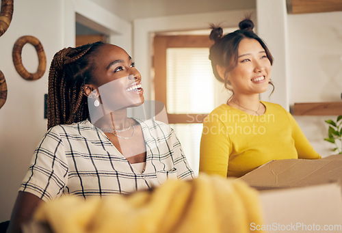 Image of Happy, smile and lesbian couple moving in their new home with cardboard boxes together in living room. Happiness, love and interracial lgbtq women homeowners in the lounge of their modern apartment.