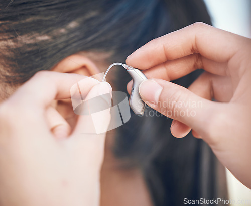 Image of Closeup, hands and hearing aid support for person, listening help and medical gear. Healthcare, woman with a disability and audio health, clinic innovation and device for sound waves or communication