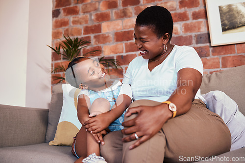 Image of Happy, relax and a mother on the sofa with a child for conversation, bonding and family in a house. Smile, care and an African mom or woman with a girl kid on the living room couch for talking