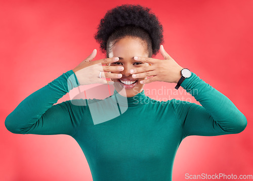 Image of Hands, cover face and woman in studio with hiding and eyes peak with a smile. African female person, red background and happy with secret and model from Chicago with gossip announcement and portrait