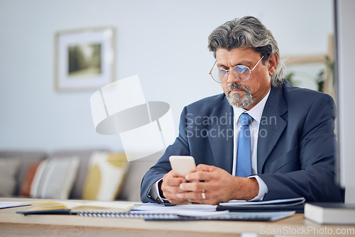 Image of Phone, networking and mature businessman in the office typing a text message on social media. Serious, technology and professional male lawyer browsing on the internet with a cellphone in workplace.