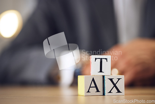 Image of Business person, hands and blocks for tax, financial advisor or accounting on office desk. Letter or word of finance accountant, lawyer or real estate in revenue, property investment or loan income