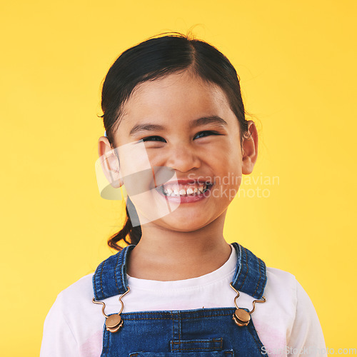 Image of Happy, portrait and girl child with smile in studio for confidence, excited and positive attitude. Face, teeth and young kid from Mexico with happiness, pose and youth isolated on a yellow background