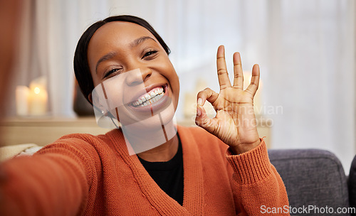 Image of Selfie, black woman and ok hand sign at home with a smile for success, motivation and perfect. Portrait, happy and African female person in a living room with a like, yes and emoji gesture at house