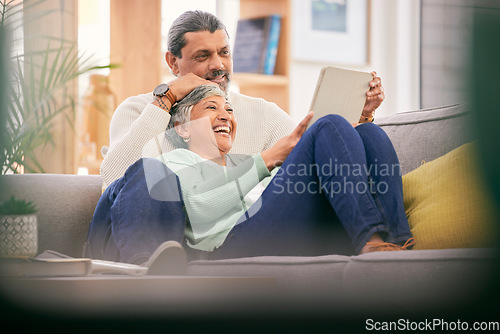 Image of Mature couple, relax and happy on sofa with tablet for streaming a funny, comedy show or movie together in lounge. Reading, man and woman in retirement with social media or app for communication