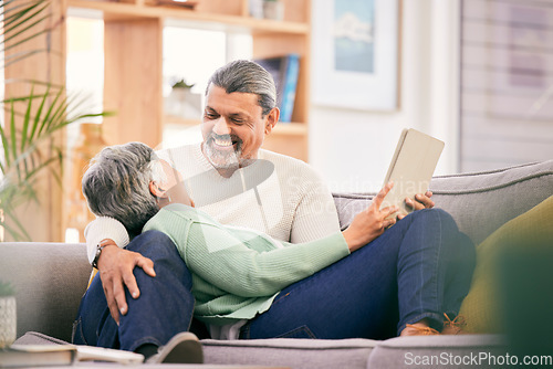 Image of Happy, mature couple and relax on sofa with tablet for streaming a funny, comedy show or movie together in lounge. Love, man and woman in retirement with social media or mobile app for communication