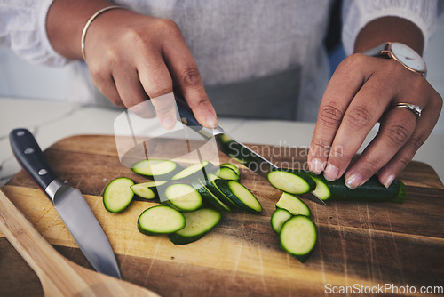 Image of Cooking, food and hands with cucumber in kitchen on wooden board for cutting, meal prep and nutrition. Healthy diet, ingredients and person with vegetables for vegetarian dinner, lunch and salad