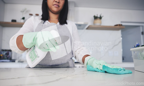 Image of Woman, hands and cleaning kitchen table with spray bottle, detergent or bacteria or germ removal at home. Female person, maid or cleaner wiping surface with cloth in clean hygiene or sanitize house