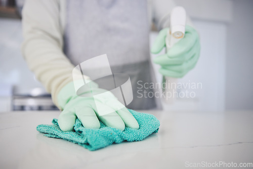 Image of Person, hands and cleaning table with spray bottle in kitchen hygiene, germ or bacteria removal at home. Closeup of maid or cleaner wiping counter with cloth and detergent in healthy disinfection