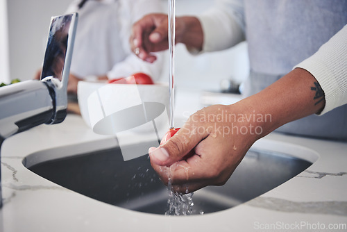 Image of Water, tomato and person hands cleaning vegetable for cooking in a kitchen basin or sink in a home for hygiene. Salad, food and chef prepare produce for a supper, lunch or dinner for diet meal