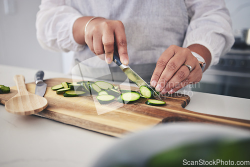 Image of Cut, cucumber and hands cooking vegetable in a kitchen on a board or table in a home for hygiene as a chef. Salad, food and person prepare produce for a supper, lunch or dinner for diet meal