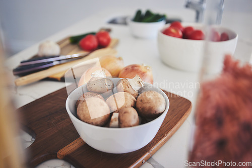 Image of Cooking, food and vegetables on kitchen counter for meal prep, cutting and nutrition on wooden board. Healthy diet, ingredients and closeup of mushrooms in bowl for vegan dinner, lunch and supper