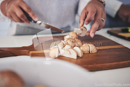 Image of Cut, mushroom and person hands cooking vegetable in a kitchen on a board or table in a home as healthy a chef. Salad, food and woman prepare produce for a supper, lunch or dinner for diet meal