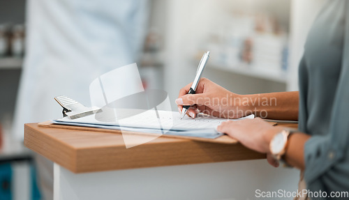 Image of Hands of woman at pharmacy, clipboard and medical insurance information at counter for script medicine. Prescription, writing and patient at pharmacist with application form for pharmaceutical drugs.