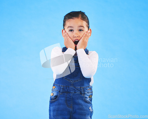 Image of Portrait, wow and girl excited, surprise and announcement on a blue studio background. Female kid, shock or model with hands on face, emoji and prize with a winner, giveaway or news with mockup space