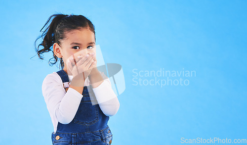 Image of Girl child, cover mouth and studio portrait with mockup space for promotion, secret or sale by blue background. Female kid, silence and hands on lips for deal, news and fashion model with information