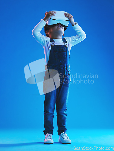 Image of Glasses, virtual reality and metaverse with girl, futuristic and digital transformation on a blue studio background. Kid, person and model with vr headset for video games, future or augmented reality