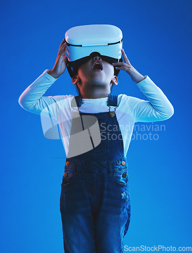 Image of Wow, girl and kid with virtual reality glasses, futuristic and metaverse on a blue studio background. Child, person and model with vr headset, future and online gaming with expression and technology